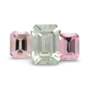 Three emerald-cut pink and pale green loose gemstones